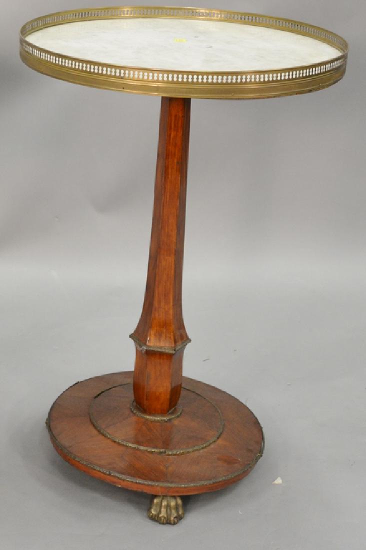 Continental stand with galleried round marble top on: Continental stand with galleried round marble top on pedestal with brass paw feet, early 19th century. ht. 30 in., dia. 20 in. Provenance: Estate of Kenneth Jay Lane*IMPORTANT NOTE: No credit card pay