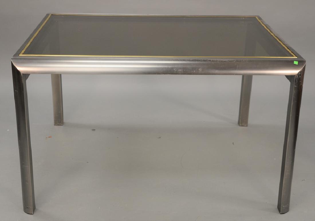 Expanding dining table by Brueton, in brushed metal: Expanding dining table by Brueton, in brushed metal with a brass plated trim detail. ht. 30 in., top closed: 41 1/2" x 52", top open: 41 1/2" x 104"