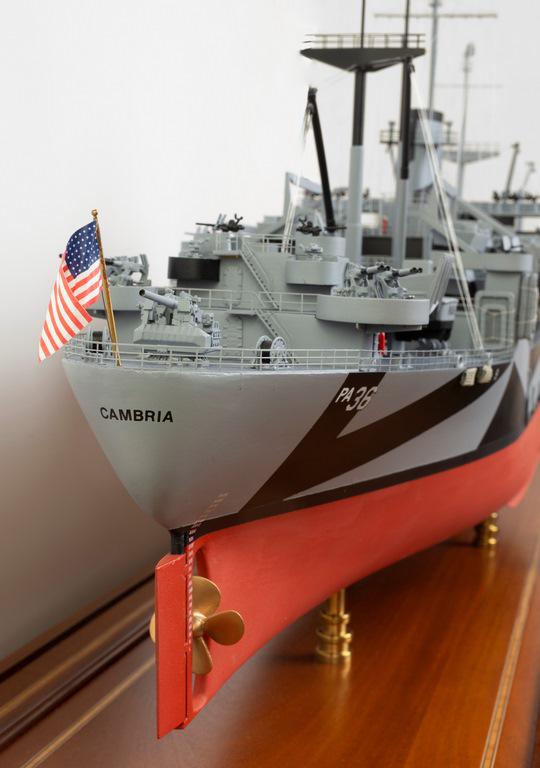MODEL OF THE USS CAMBRIA (APA-36) DURING THE 1945: MODEL OF THE USS CAMBRIA (APA-36) DURING THE 1945 OKINAWA CAMPAIGN This full hull, 1/4 scale model of a Bayfield Class attack transport is mounted on two brass pedestal supports and presented in a cus
