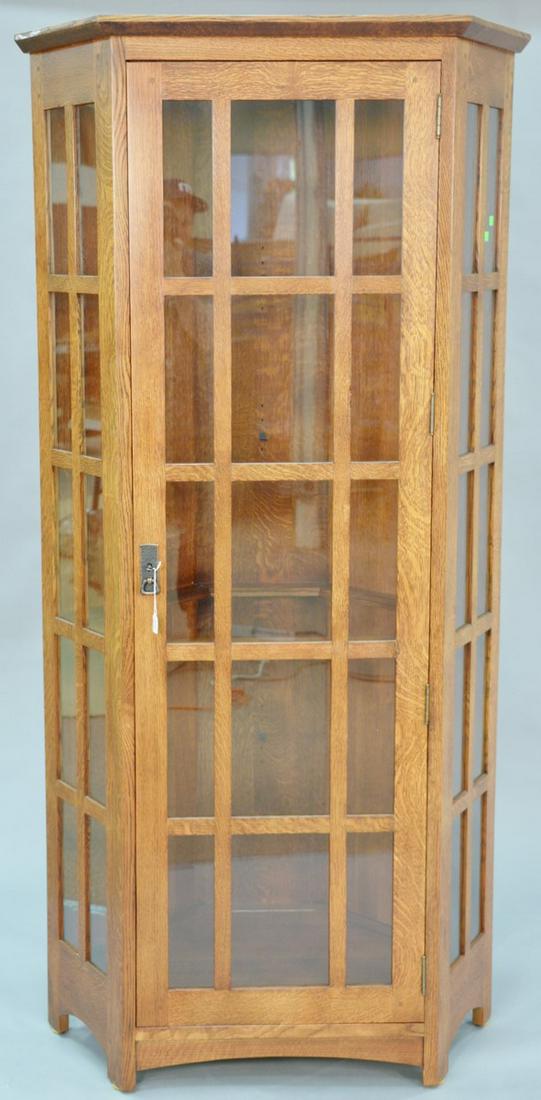 Stickley oak corner cabinet with four glass shelves.: Stickley oak corner cabinet with four glass shelves. ht. 79 in.