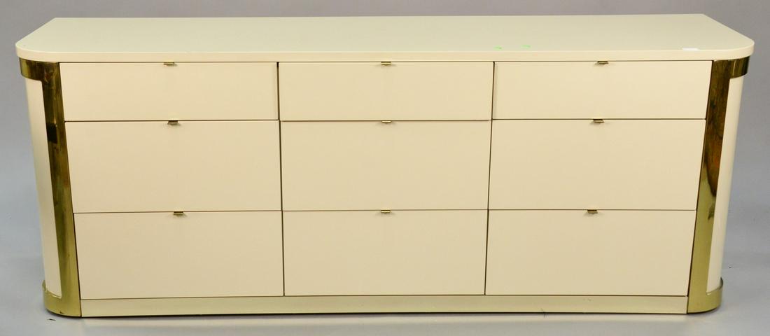 John Stewart nine-drawer commode, mid-century design,: John Stewart nine-drawer commode, mid-century design, graduated drawers with brass tab pulls, lacquered finish, gold metal trim, signed in drawer, ht. 29 1/4", top 19 1/2" x 75", Provenance: Estate of