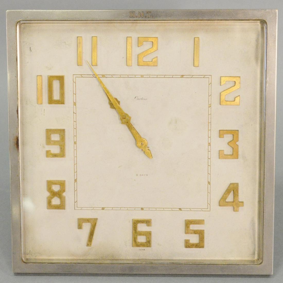 Cartier Art Deco alarm mantle clock, having silvered: Cartier Art Deco alarm mantle clock, having silvered square frame with gold numbers and hands, face marked "Cartier 8 Days Swiss Eterna Brevet" on back, 8" x 8".