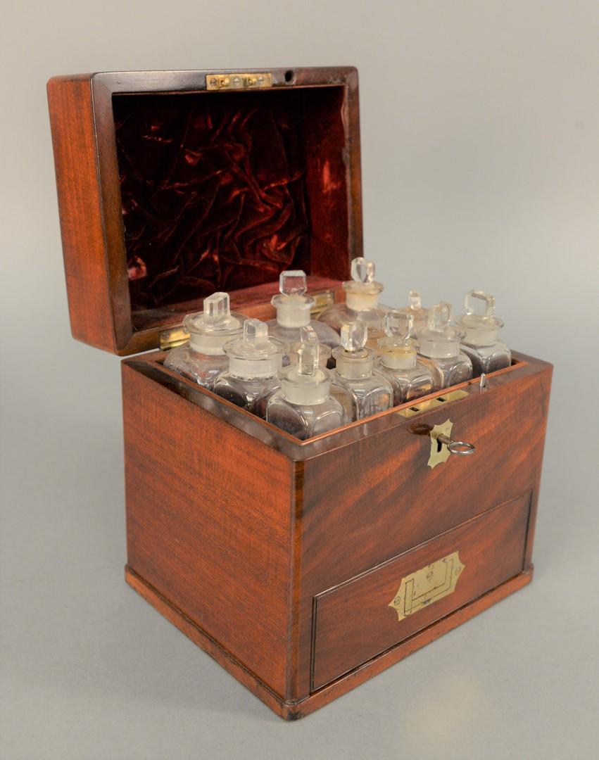 Mahogany Medical Apothecary Box, opening to fitted: Mahogany Medical Apothecary Box, opening to fitted interior having twelve bottles over drawer opening to fitted interior with scale, bottles, and a Royal Worcester measuring cup, 19th century.height: 