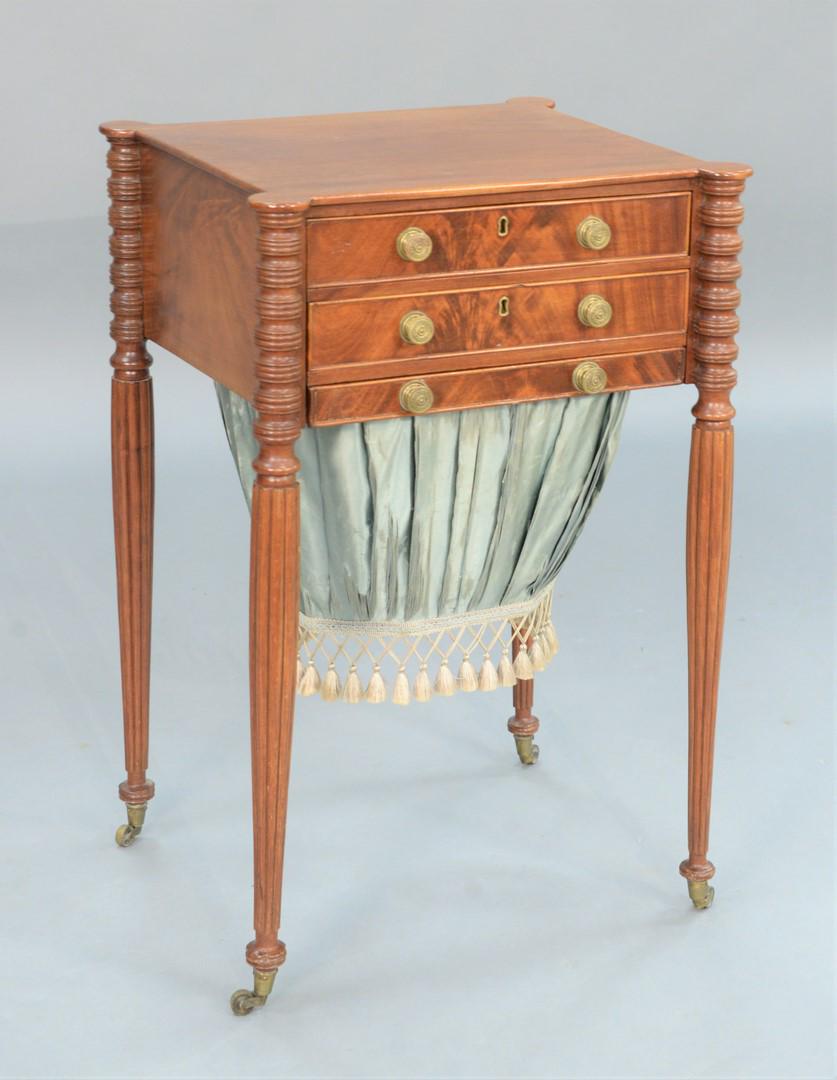 Sheraton Mahogany Work Table having top with turret: Sheraton Mahogany Work Table having top with turret corners over three drawers, lower with silk bag, set on turned and fluted legs ending in brass capped feet with wheels.height 29 3/4 inches, top 17 