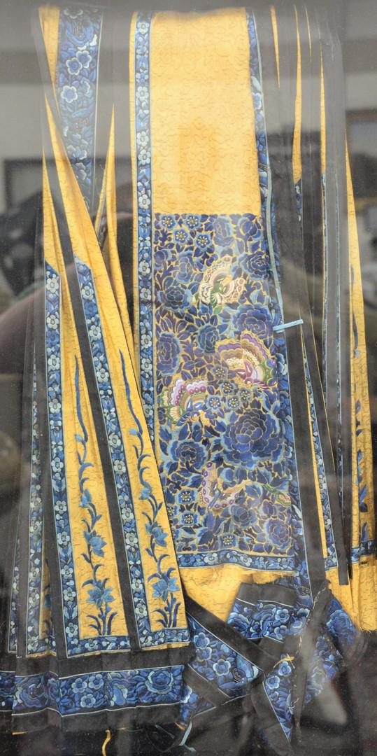 Chinese Silk Embroidered Wall Hanging or Panel having: Chinese Silk Embroidered Wall Hanging or Panel having golden tan ground embroidered with blue flowers and brightly colored butterflies, folded in shadow box frame.sight size: 30 1/4" x 15 1/2".Provena