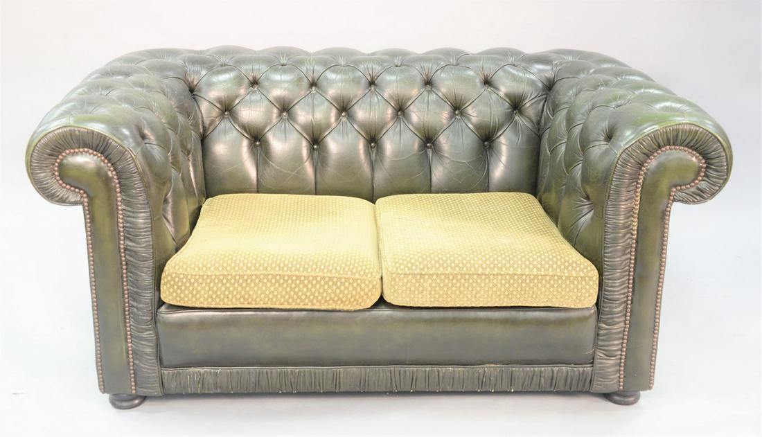 A Chesterfield style green tufted leather loveseat with: A Chesterfield style green tufted leather loveseat with upholstered cushions, 28" x 60-1/2" x 35".