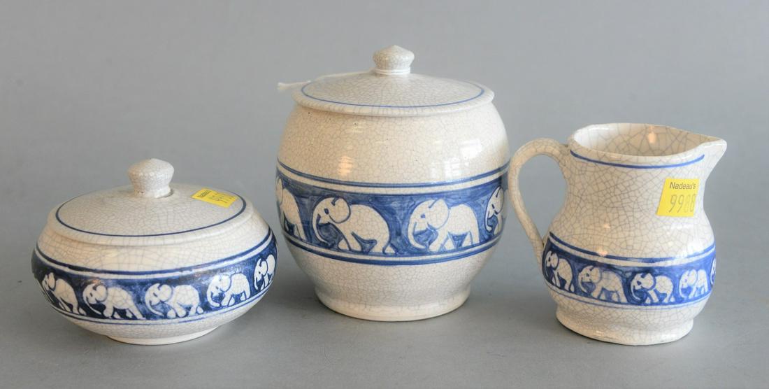 Three Dedham Pottery Pieces with elephant border, two: Three Dedham Pottery Pieces with elephant border, two covered jars and a creamerhaving crackle glaze with blue Dedham Pottery stamp on bottomjar heights: 3 inches, 5 inchescreamer height: 3 1/4 inches