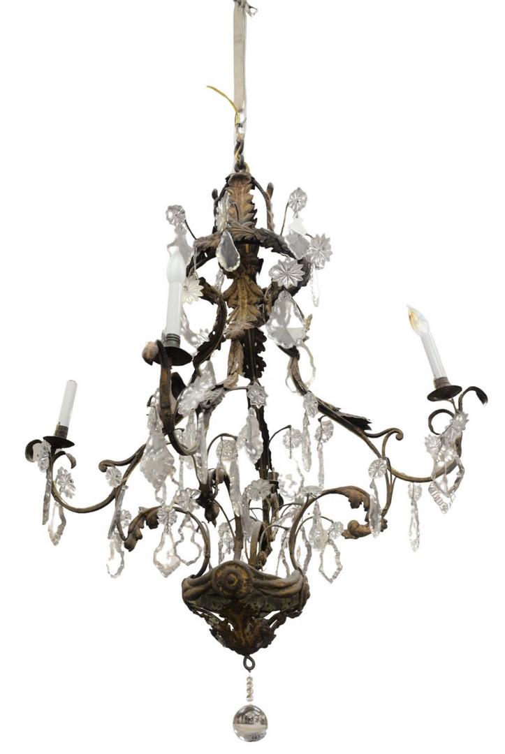 French Rococo Chandelier having four iron arms with: French Rococo Chandelier having four iron arms with metal leaf and crystal prism, height 48 in., diameter 36 in. Provenance: The Estate of Gloria Schiff, 630 Park Avenue, New York.