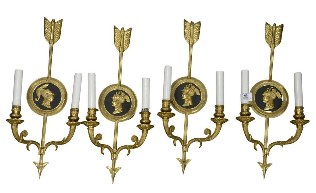 Set of Four Gilt Bronze Wall Sconces, each having two: Set of Four Gilt Bronze Wall Sconces, each having two lights, body having an arrow form and each having an inset black panel of Zeus, height 19 1/4 inches, width 8 1/2 inches.