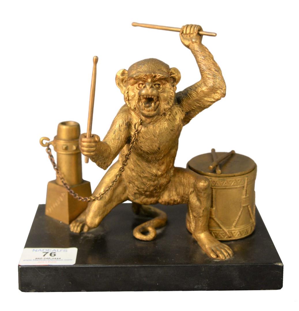 An Alexandre Leonard Desk Set, having a gilt bronze: An Alexandre Leonard Desk Set, having a gilt bronze monkey with a drum form inkwell holding drum sticks and chained to a post form pen holder, height 7 inches, width 7 inches, depth 4 1/2 inches.