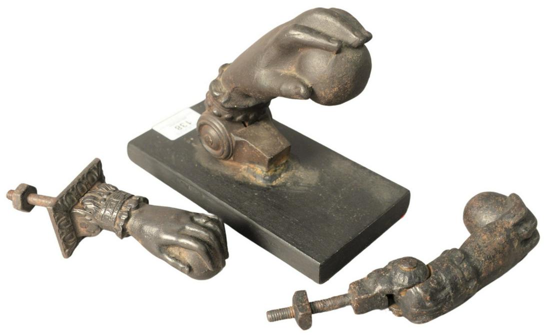 Three Piece Lot of Cast Iron Door Knockers, each in the: Three Piece Lot of Cast Iron Door Knockers, each in the form of a hand holding a ball, largest height 7 inches, width 4 inches, depth 6 inches.