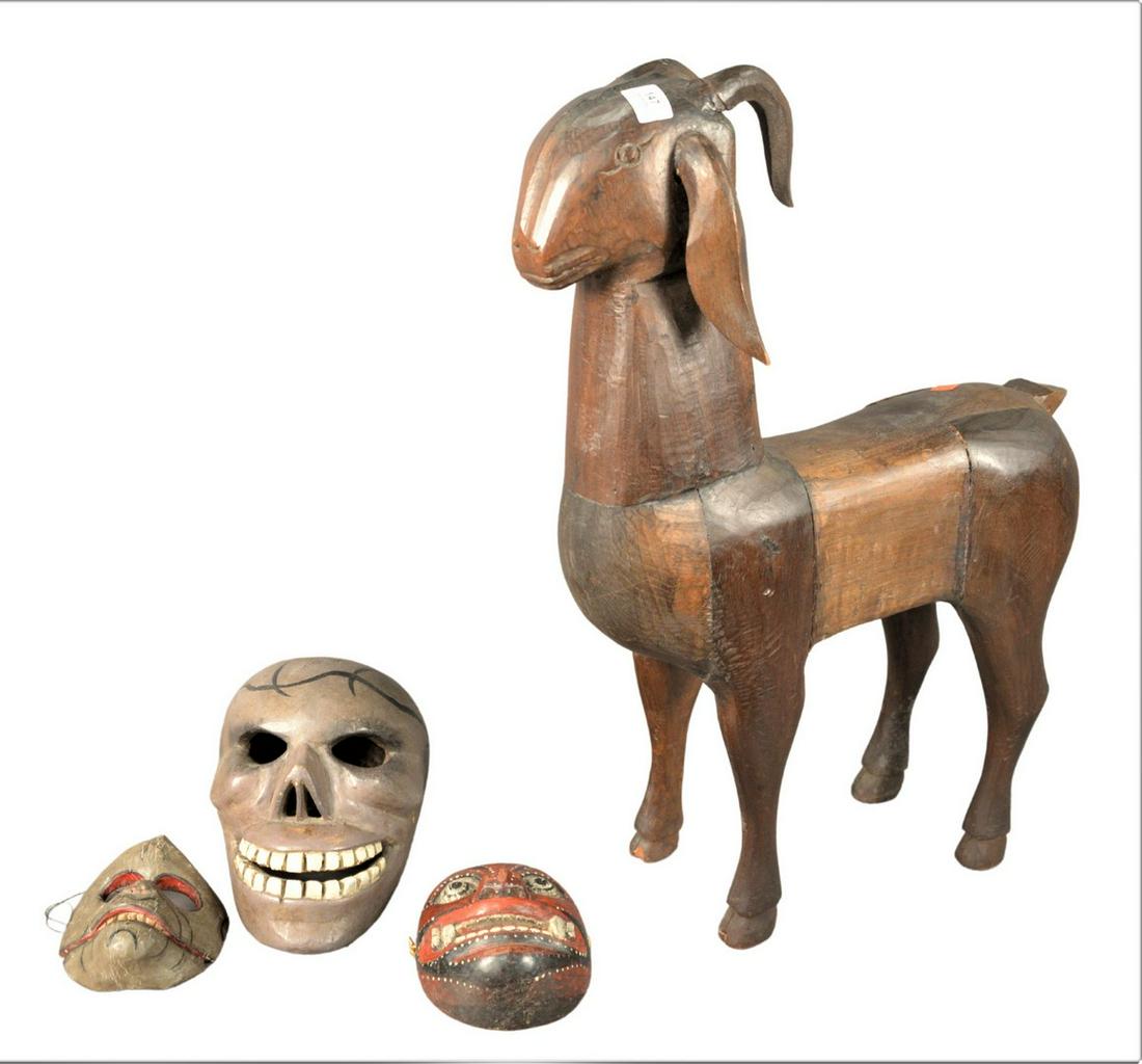 Four Piece Group, to include large wood carved goat: Four Piece Group, to include large wood carved goat with repairs and loss to the front left hoof, unsigned, height 29 1/2 inches; along with three carved and painted masks, height 11 1/2 inches, depth