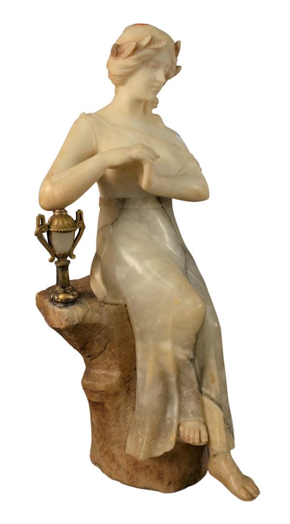 Carved Alabaster Female Figure, seated on a rock with a: Carved Alabaster Female Figure, seated on a rock with a mounted light post form, also having incised floral details on her dress, height 24 1/2 inches, width 9 inches, depth 10 1/2 inches, (repaired).