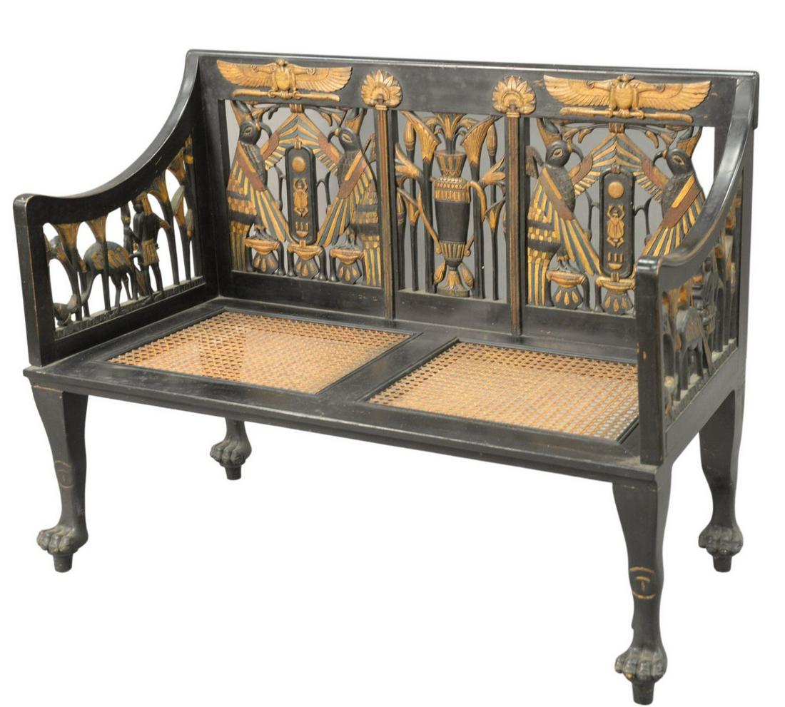 Egyptian Revival Ebonized Settee, having pierced,: Egyptian Revival Ebonized Settee, having pierced, carved back and arm supports with caned seats and paw feet, height 37 inches, length 49 inches, depth 23 inches.