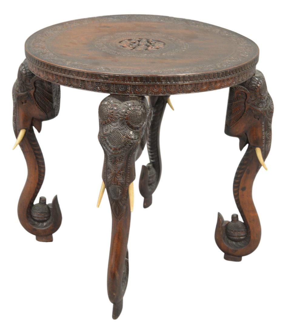 Hardwood Table, having carved top on elephant carved: Hardwood Table, having carved top on elephant carved legs, height 25 inches, diameter 24 inches.
