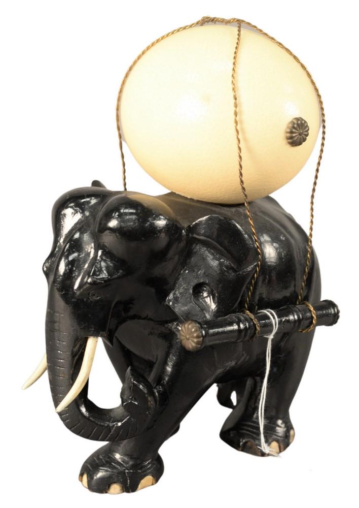 Wood Carved Elephant, in ebonized lacquer carrying: Wood Carved Elephant, in ebonized lacquer carrying ostrich egg, height 13 inches, length 10 inches.