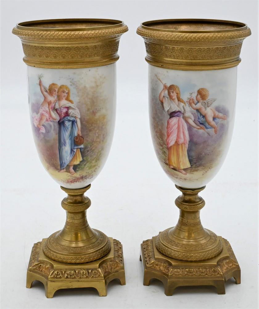 Pair of French Porcelain and Bronze Garniture Urns,: Pair of French Porcelain and Bronze Garniture Urns, each having gilt bronze top over painted scene with maiden and putti figure, on bronze base, height 9 1/4 inches.