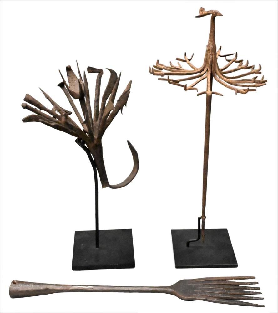 Three Piece Iron Group, to include two medicine staffs, Yoruba Tribe, patinated iron with central: Three Piece Iron Group, to include two medicine staffs, Yoruba Tribe, patinated iron with central bird motif, height 15 inches, diameter 9 inches, and height 20 inches, diameter 9 inches; along with a