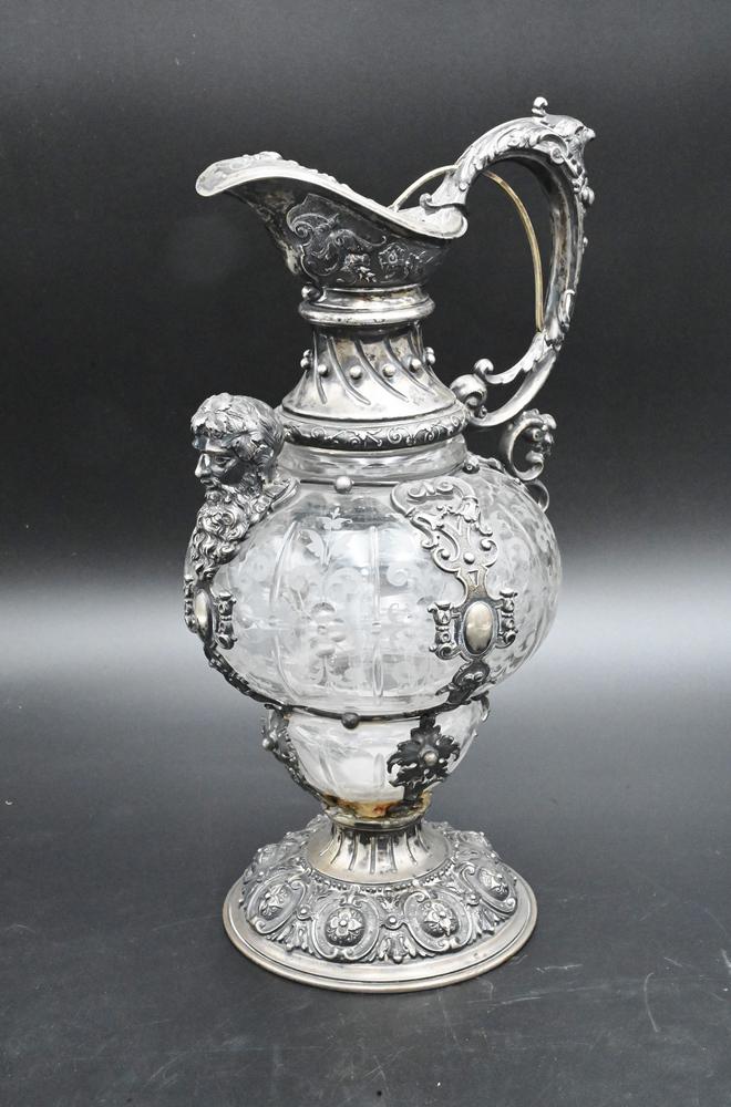 Continental Silver and Frosted Crystal Claret Jug, having bird head handle and north wind face on: Continental Silver and Frosted Crystal Claret Jug, having bird head handle and north wind face on front, (as is) on base reglued and resoldered, height 12 3/4 inches.