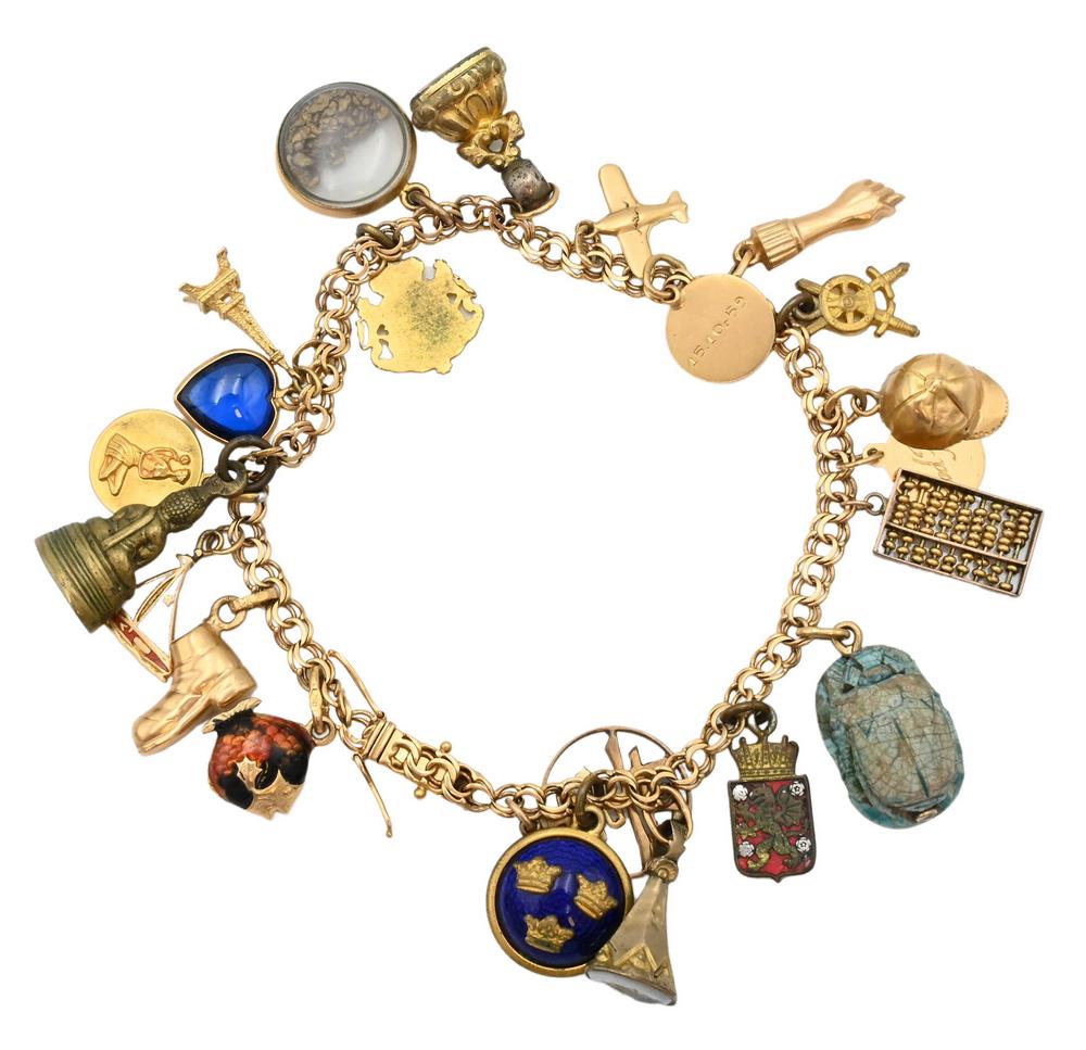 18 Karat Gold Charm Bracelet, to include charms, 18 karat, 14 karat, along with plated, plus scarab;: 18 Karat Gold Charm Bracelet, to include charms, 18 karat, 14 karat, along with plated, plus scarab; total weight 32.5 grams.