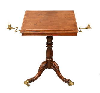 Regency Mahogany Book Stand with Tilting Top Surface: Regency Mahogany Book Stand with Tilting Top Surface flanked by adjustable candle holders on carved base set on three downswept members having brass feet and wheels, 19th century height 29 inches, top