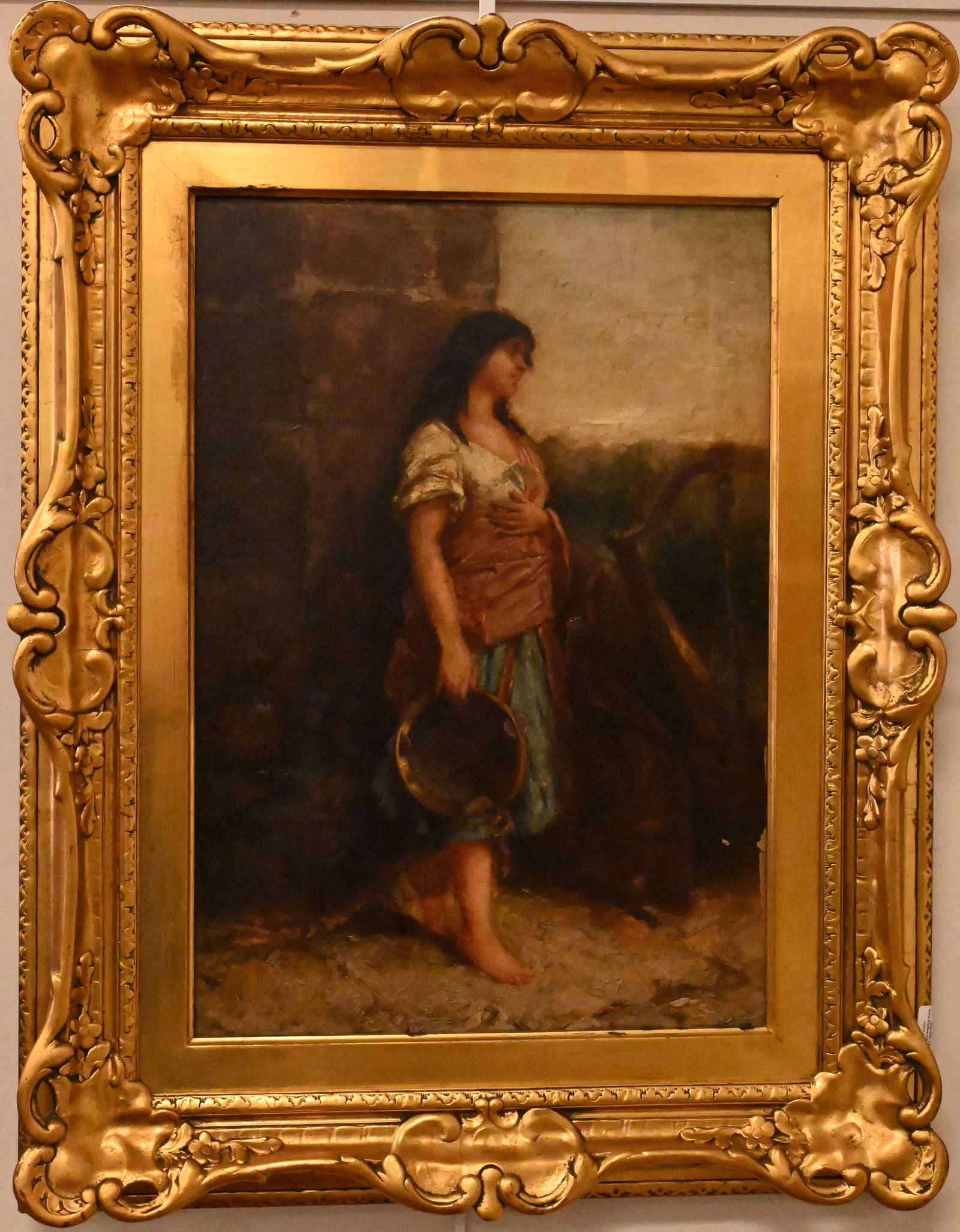 Continental School 19th Century: Continental School 19th Century Full length portrait of a Spanish woman with a tambourine and harp leaning against a wall Oil on canvas in ornate gilt frame Unsigned 20" x 14"