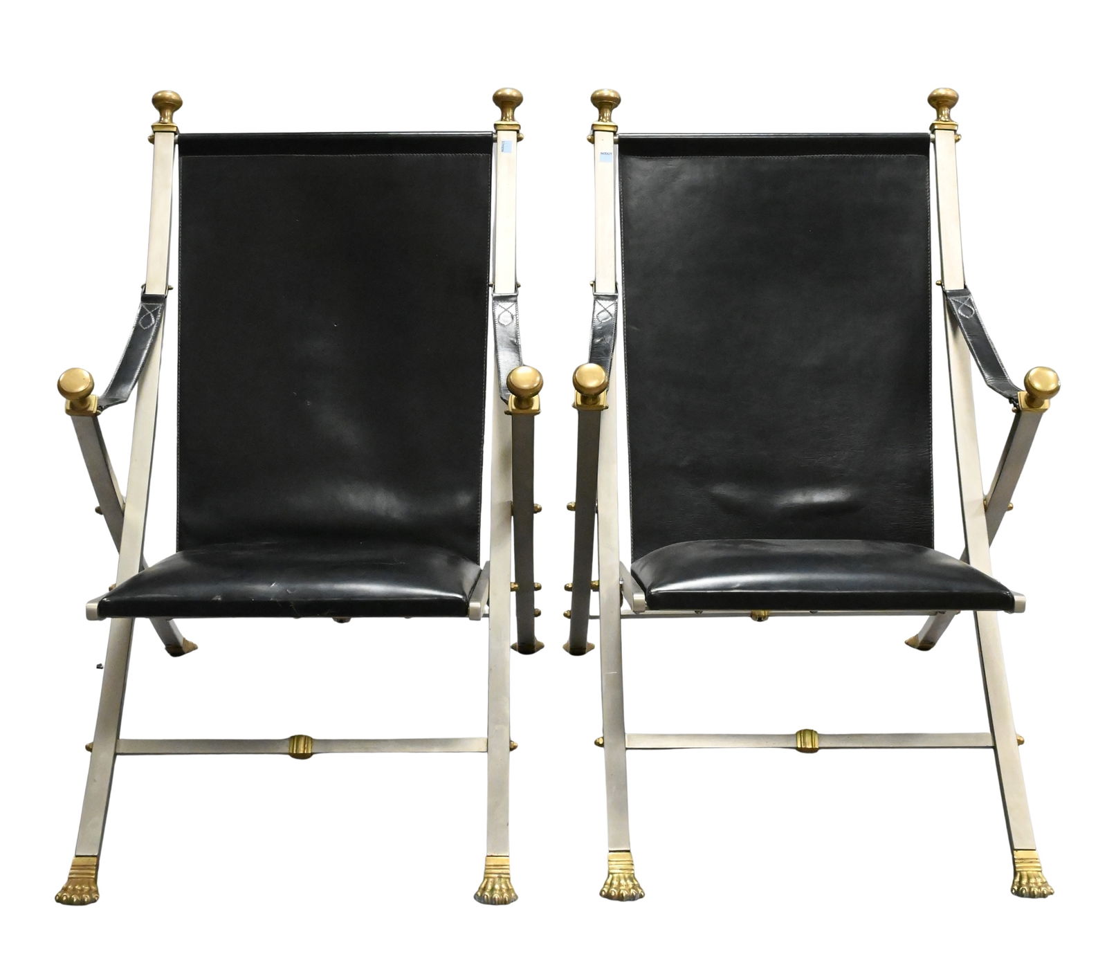 Pair of Maison Jansen Folding Leather Campaign Arm Chairs: Pair of Maison Jansen Folding Leather Campaign Armchairs having brushed steel frame with brass capped finials and paw feet, feet marked "Italy" to underside height 36 inches, width 25 inches
