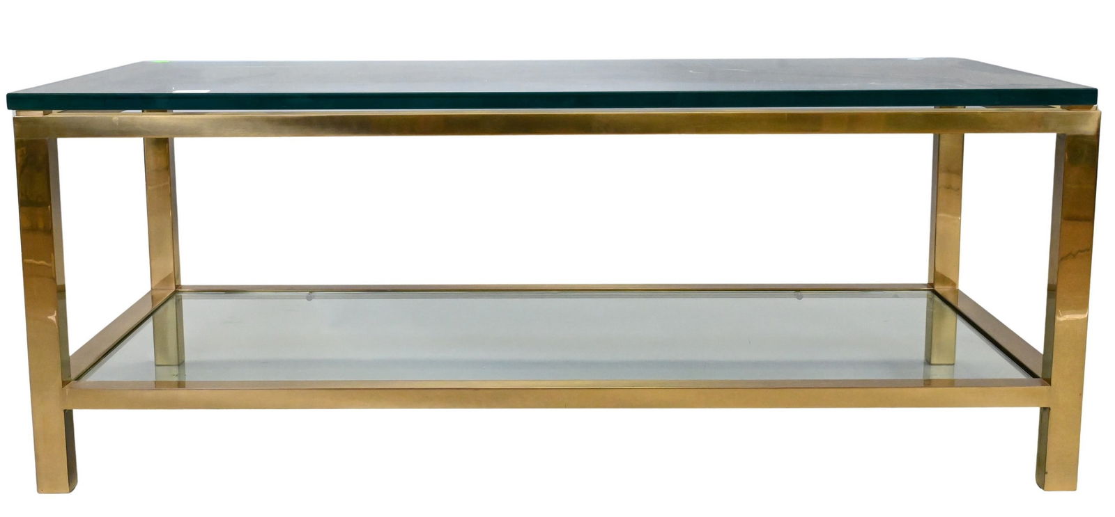 In the Manner of Karl Springer Modern Brass and Glass Top Coffee Table: In the Manner of Karl Springer Modern Brass and Glass Top Coffee Table having two tiers, purchase price $4,500 height 18 1/2 inches, top 24" x 48" Provenance: Property from a Private Collection at 791