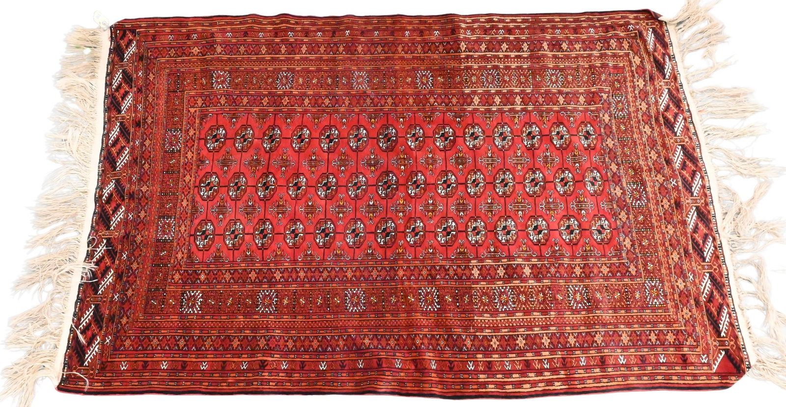 Tekke Turkoman Rug: Tekke Turkoman Rug the claret-ground three rows of fourteen-shaped octagonal guls in multiple borders of flower heads, zig-zags and latch hooks, early 20th century 4'3" x 6' 7" Provenance: