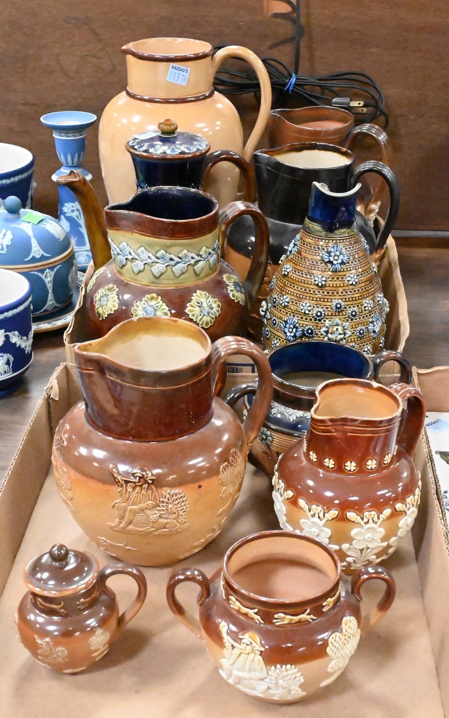 12 Piece Group of Doulton Lambeth Stoneware: 12 Piece Group of Doulton Lambeth Stoneware to include assorted salt-glazed and glazed pottery examples in brown and blue tones, several with applied floral sprig decoration and beaded borders.