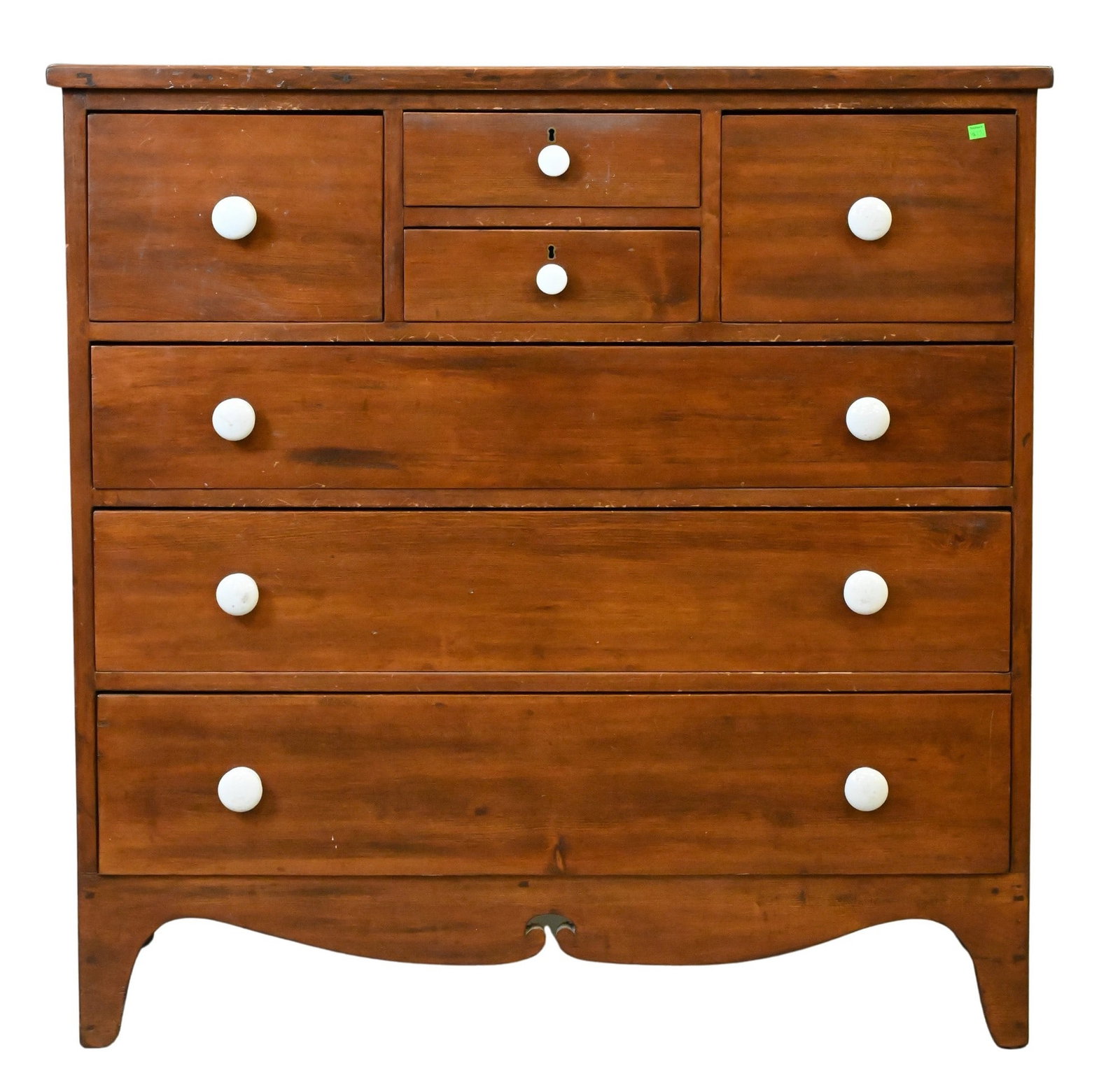 Pine Chest of Drawers: Pine Chest of Drawers Having a rectangular top above a case, two small fitted drawers over three graduated long drawers, the drawers retaining white ceramic knobs, raised on shaped bracket feet, the