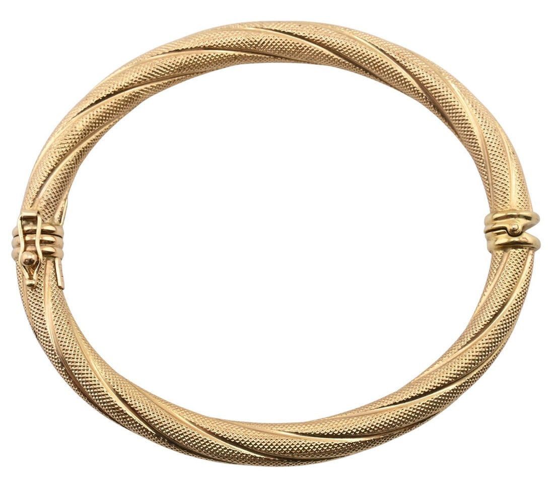 14K Yellow Gold Textured Bangle Bracelet: 14K Yellow Gold Textured Bangle Bracelet Twisted tubular bangle with fine engine-turned texture throughout, joined by a hinged clasp with safety latch. Marked 14K Italy. Outer circumference approx. 8 