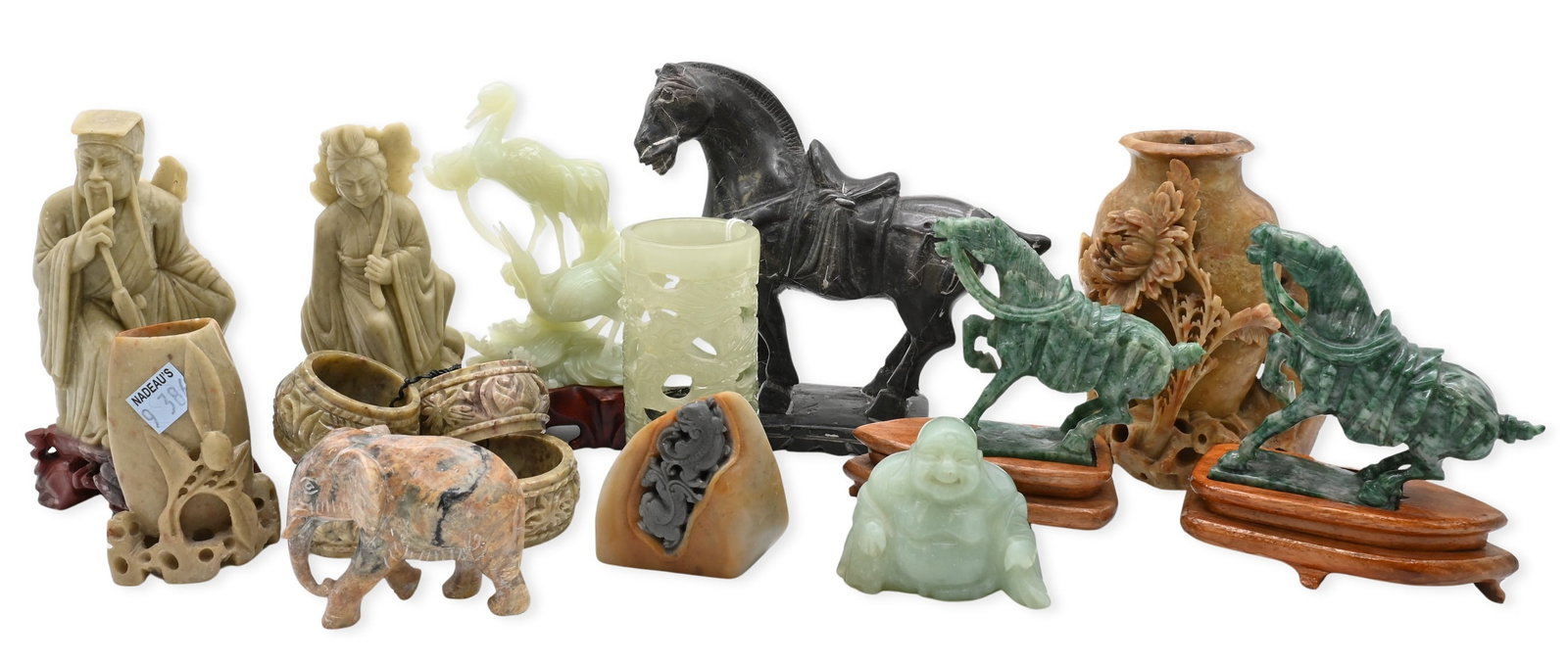 Group of Carved Asian Hardstone and Soapstone Articles: Group of Carved Asian Hardstone and Soapstone Articles comprising carved hardstone figures of immortals and deities, a laughing Buddha, elephant figure, pierced brush pot and vessels, a carved gray so
