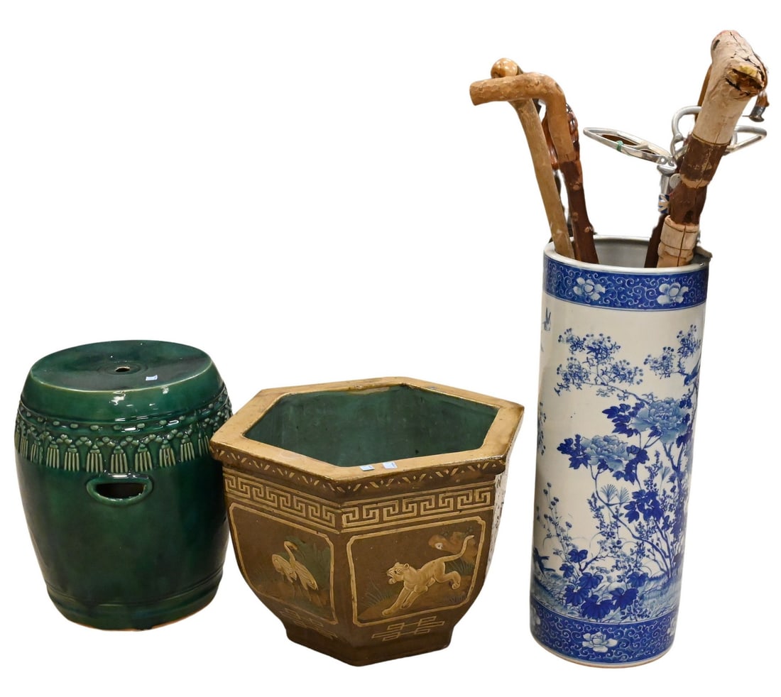 Three Large Decorative Asian Jardinieres: Three Large Decorative Asian Jardinieres including a blue and white porcelain umbrella stand decorated with birds and flowering branches and holding a group of canes and walking sticks, a green garden