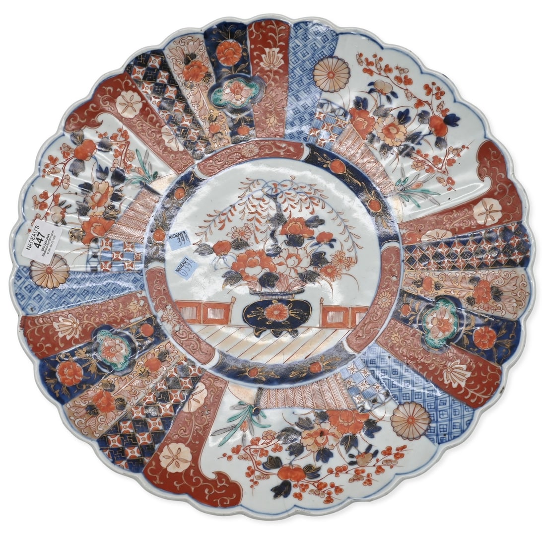 Japanese Imari Porcelain Charger: Japanese Imari Porcelain Charger of scalloped circular form, decorated featuring fan panels, floral sprays, and geometric motifs in underglaze blue, iron red, and gilt. Meiji period or later. diameter