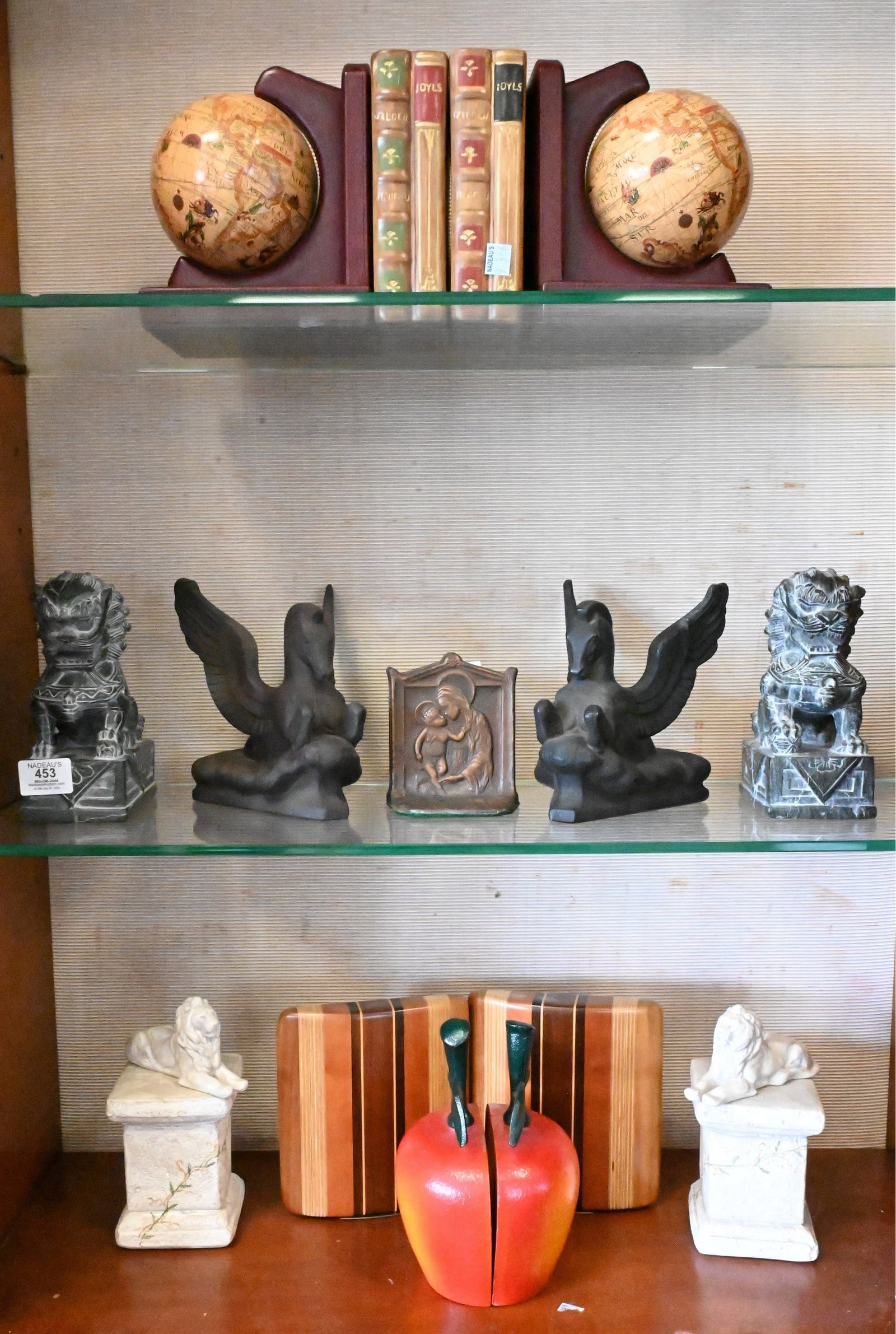 Group of Decorative Bookends: Group of Decorative Bookends to include globe-form leather bookends, faux book-form examples, winged horse Pegasus figures marked WW, recumbent lion models, carved soapstone foo dog, along with 1925 D