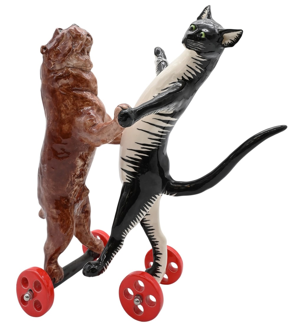 Andree Richmond (British/American, 20th/21st Century): Andree Richmond (British/American, 20th/21st Century) "Dancing Cat and Bulldog" Handcrafted porcelain sculpture depicting a dancing cat and bulldog mounted on red wheels Signed in monogram on the