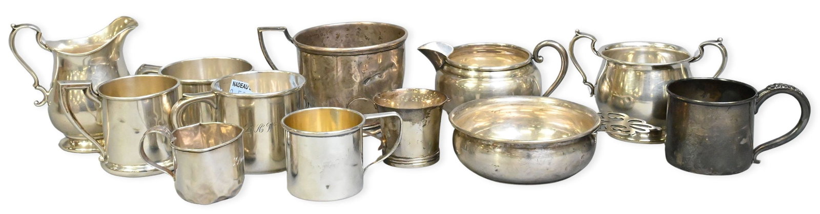 12 Sterling Silver Cups: 12 Sterling Silver Cups to include 8 handled cups, 2 creamers, 1 sugar bowl, and 1 porriger total weight 27.9 troy ounces Provenance: From a Briarcliff Manor Estate