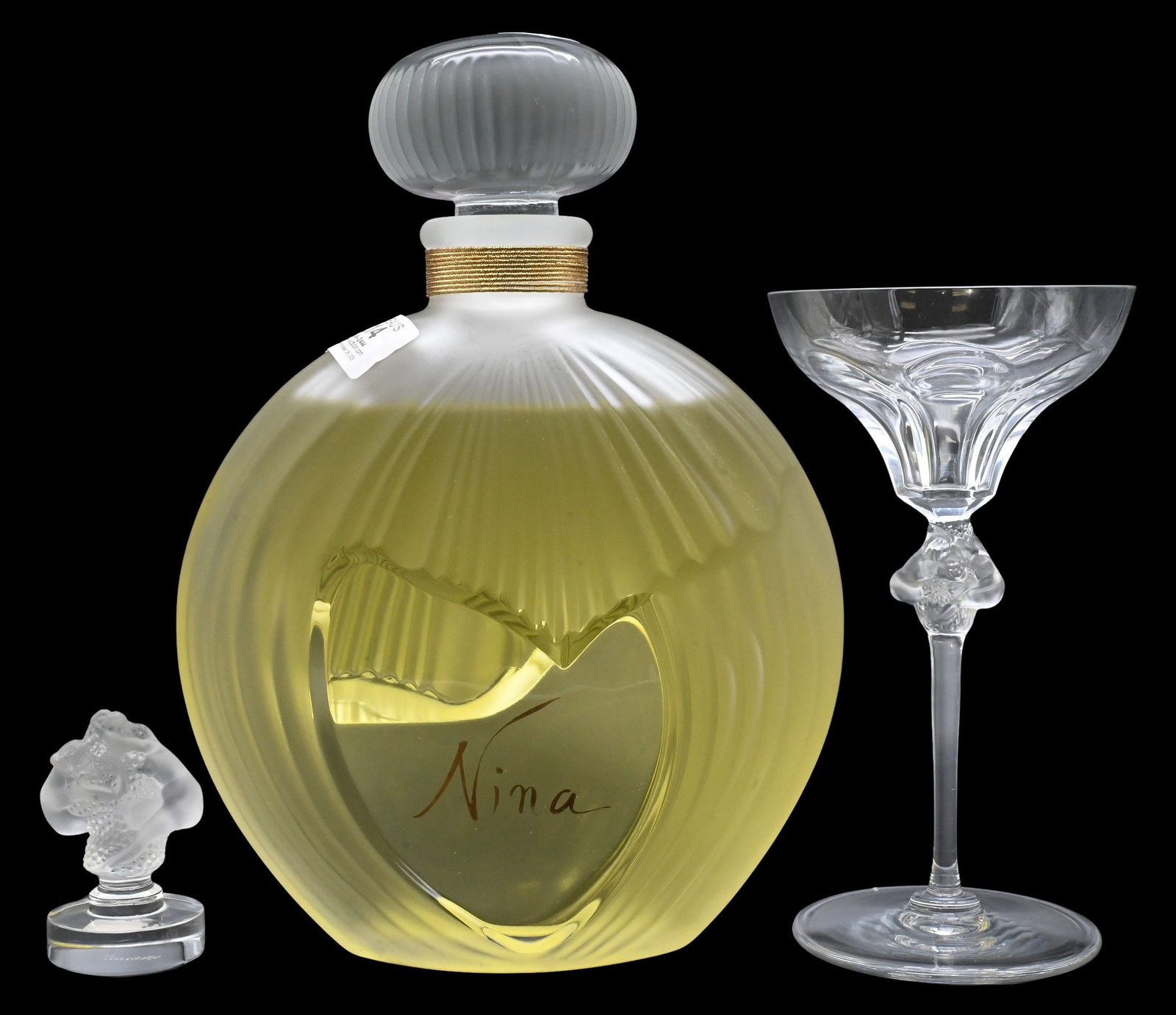 Three Piece Lalique France Crystal Group: Three Piece Lalique France Crystal Group to include large Nina Ricci "Dummy" perfume factice, stemmed martini glass and frosted crystal flower-form figurine, each signed Lalique France. perfume height