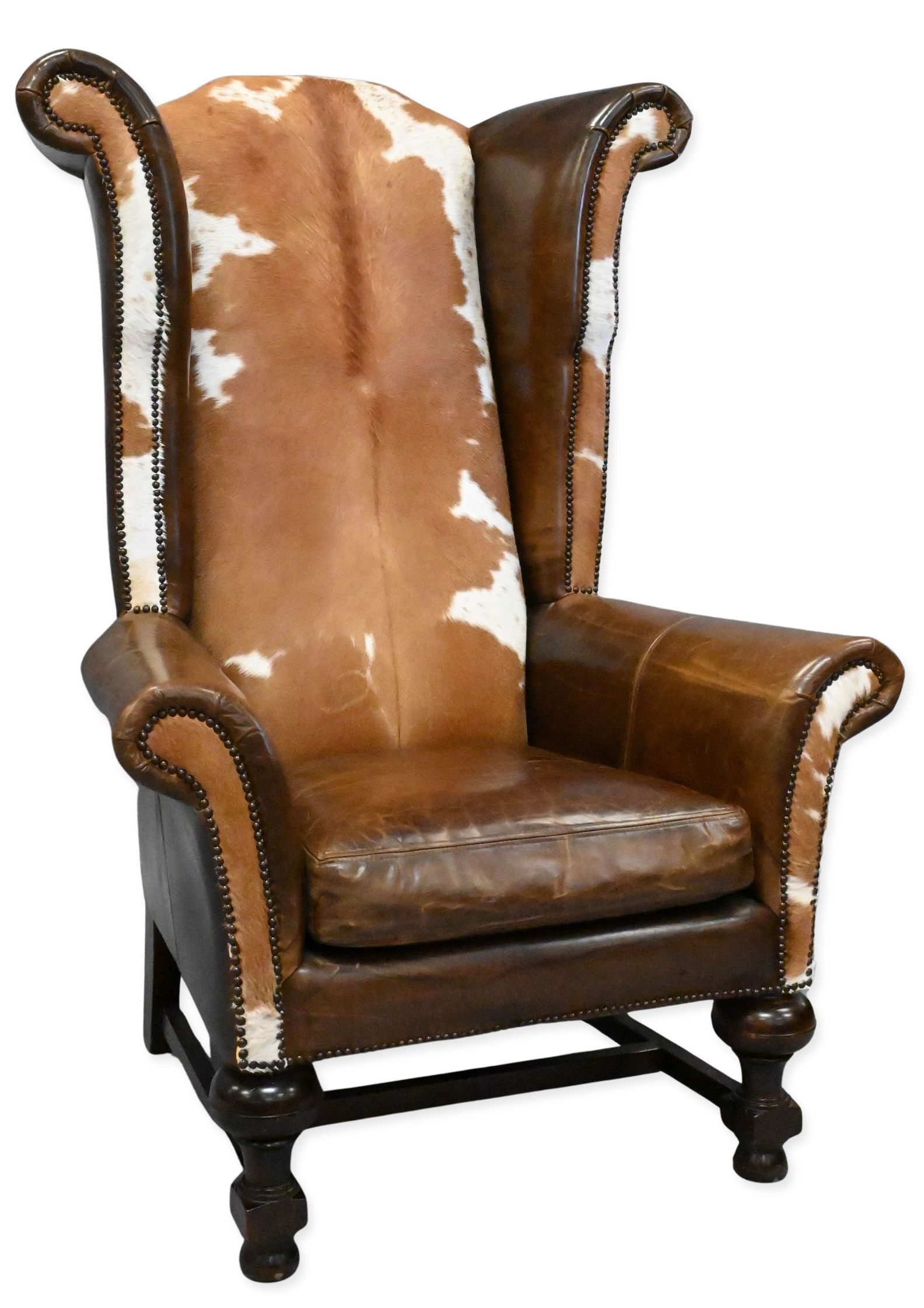 Furniture Your Way Oversized Leather and Cowhide Wingback Armchair: Furniture Your Way Oversized Leather and Cowhide Wingback Armchair having a monumental cowhide upholstered back, distressed brown leather seat and rolled arms, brass nailhead trim and turned wood legs