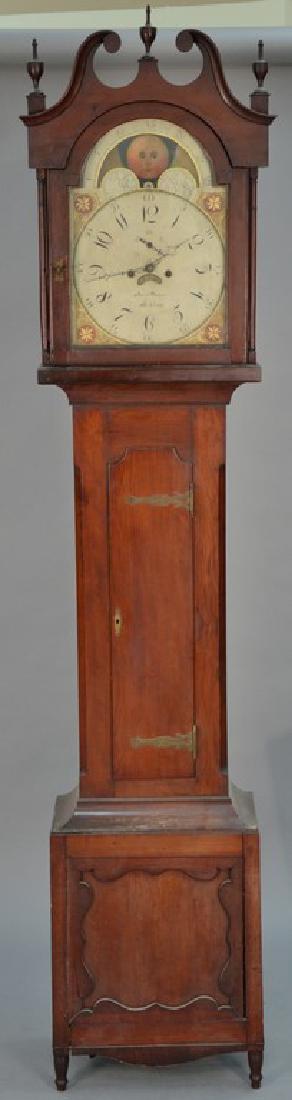 Cherry tall case clock with broken pediment top over: Cherry tall case clock with broken pediment top over tombstone door on plain case all set on turned legs, metal painted moon phase dial marked Jacob Guthard Lebanon, having calendar and second hand an