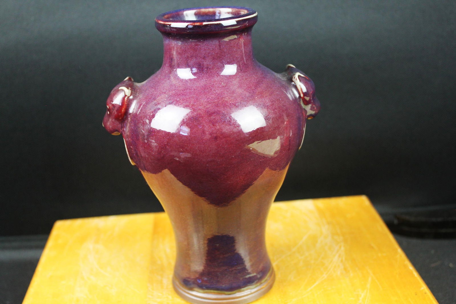 Chinese Purple-Glazed Porcelain Vase with Lion Mask Handles, 20th Century: 7''x5''x6''. A Chinese porcelain vase of baluster form, finished in a deep purple glaze with subtle tonal variation and pooling, transitioning to a lighter brownish glaze toward the lower body. The va