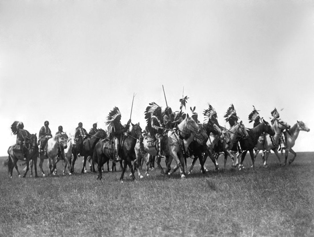C. 1900, "BRULE WAR PARTY", AFTER EDWARD SHERIFF CURTIS: ARTIST/SOURCE: EDWARD SHERIFF CURTIS, (AMERICAN, 1868-1952) CATALOGUE #: 00551 MEDIUM: CONTEMPORARY PHOTO-LITHOGRAPH, WITH EXTENSIVE RESTORATION; AFTER CURTIS' ORIGINAL NEGATIVE. DATE/PERIOD: C. 1900 