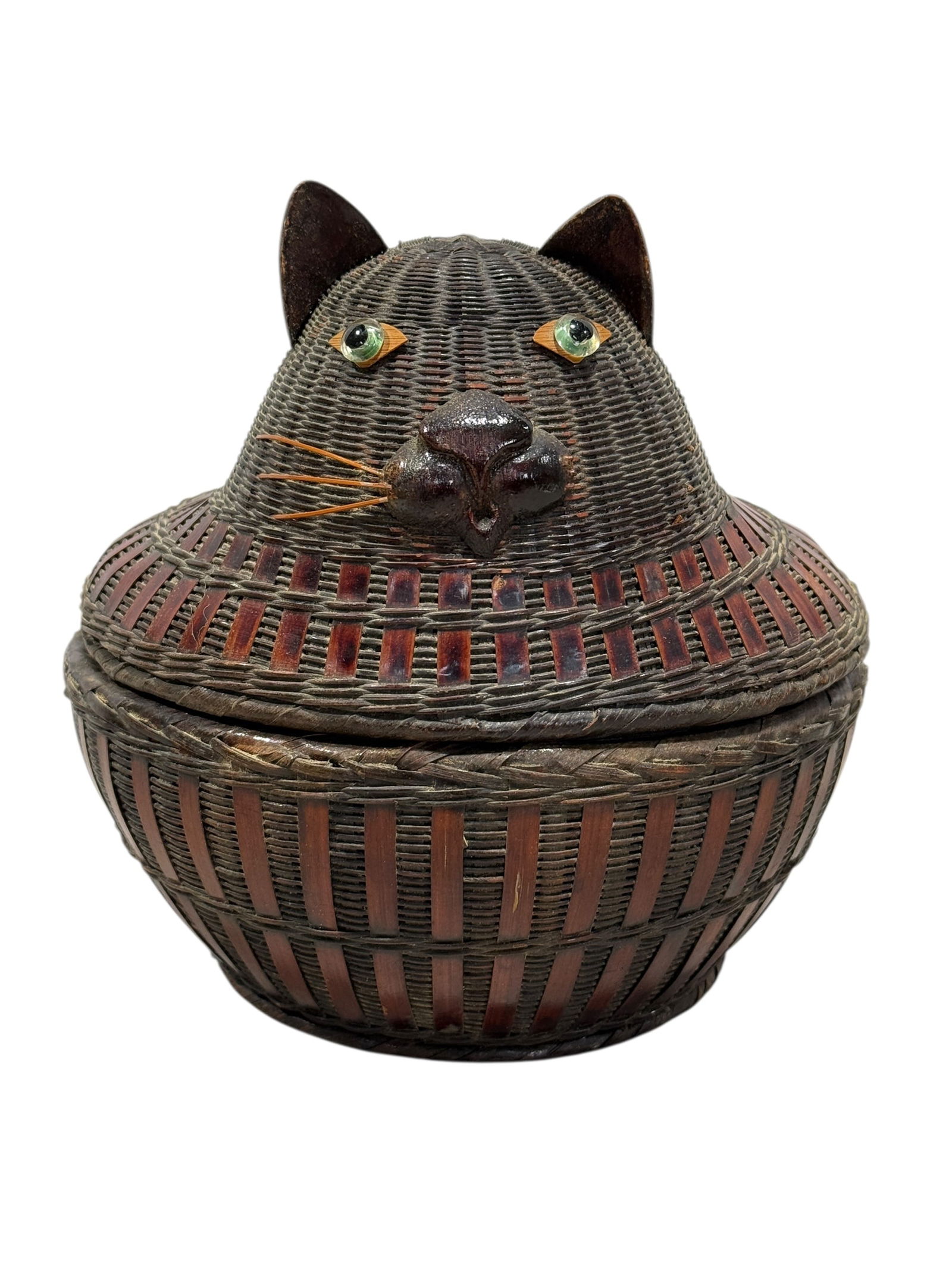 Early 20th C. Handicrafts Cat Lidded Basket: Early 20th C. Handicrafts Cat Lidded Basket. Likely from Shanghai or Zhejiang Handicrafts. Woven wicker or straw with rattan accents, wooden nose and ears and glass eyes. Measures 7" H x 7.25" Diamete
