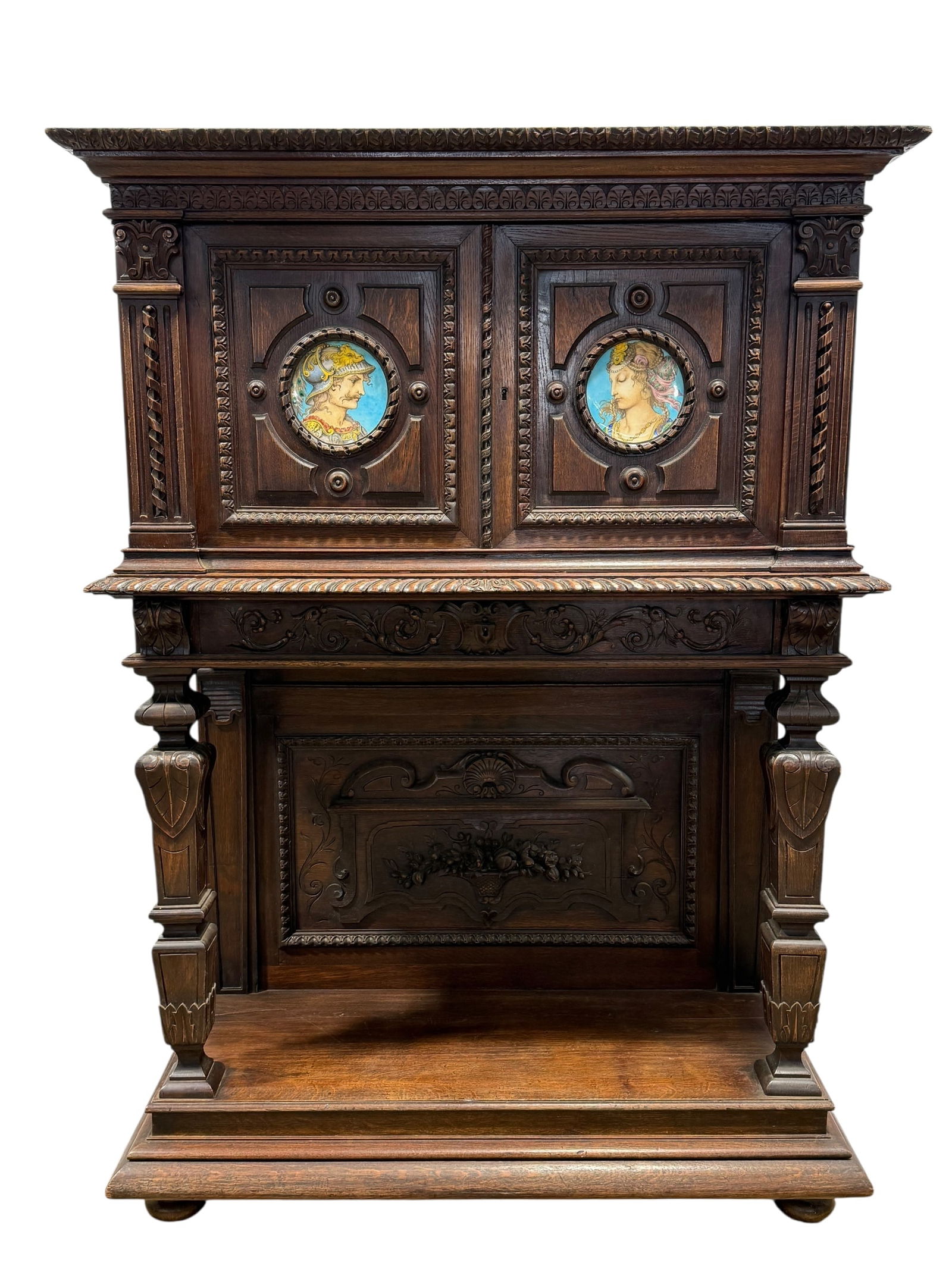19th C. French Renaissance Revival Oak Wine Cabinet w/ Sevres Plaques: 19th C. French Renaissance Revival Oak Wine Cabinet w/ Sevres Plaques. Comes with key. Sevres plaques on doors, very well carved plaque on the open bottom with carvings throughout piece and 1 drawer.