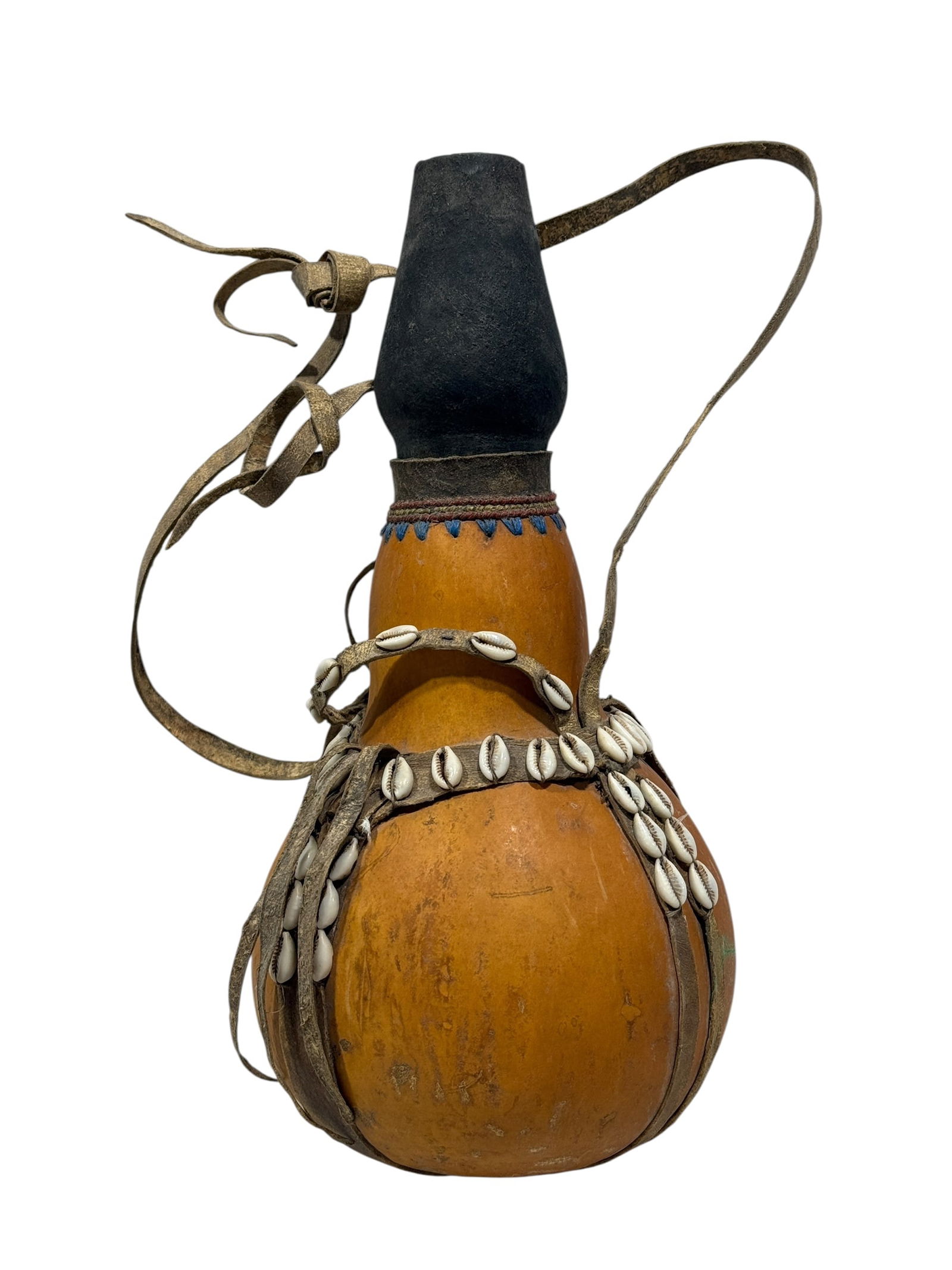 Early 1900s African Gourd Milk Container: Early 1900s African Gourd Milk Container. Hand crafted from natural materials like gourd, leather and cowrie shells. Measures 13.5" H x 6.5" W x 6.5" D. Condition reflects its age.