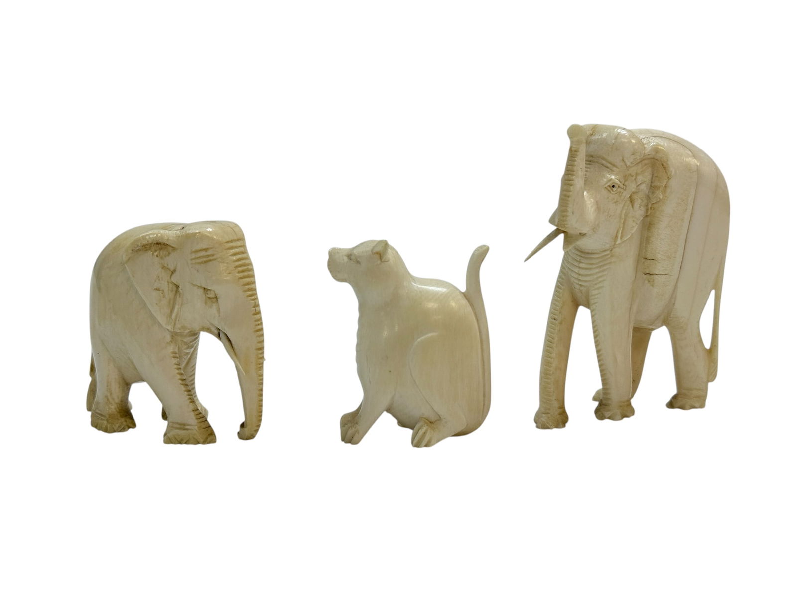 2 Carved Bone Elephants & 1 Carved Bone Cat: 2 Carved Bone Elephants & 1 Carved Bone Cat. Cat measures 2" Tall and has a broken ear. Elephants measure 2.25" Tall & 3" Tall, 1 is missing a tusk. All have some cracks.