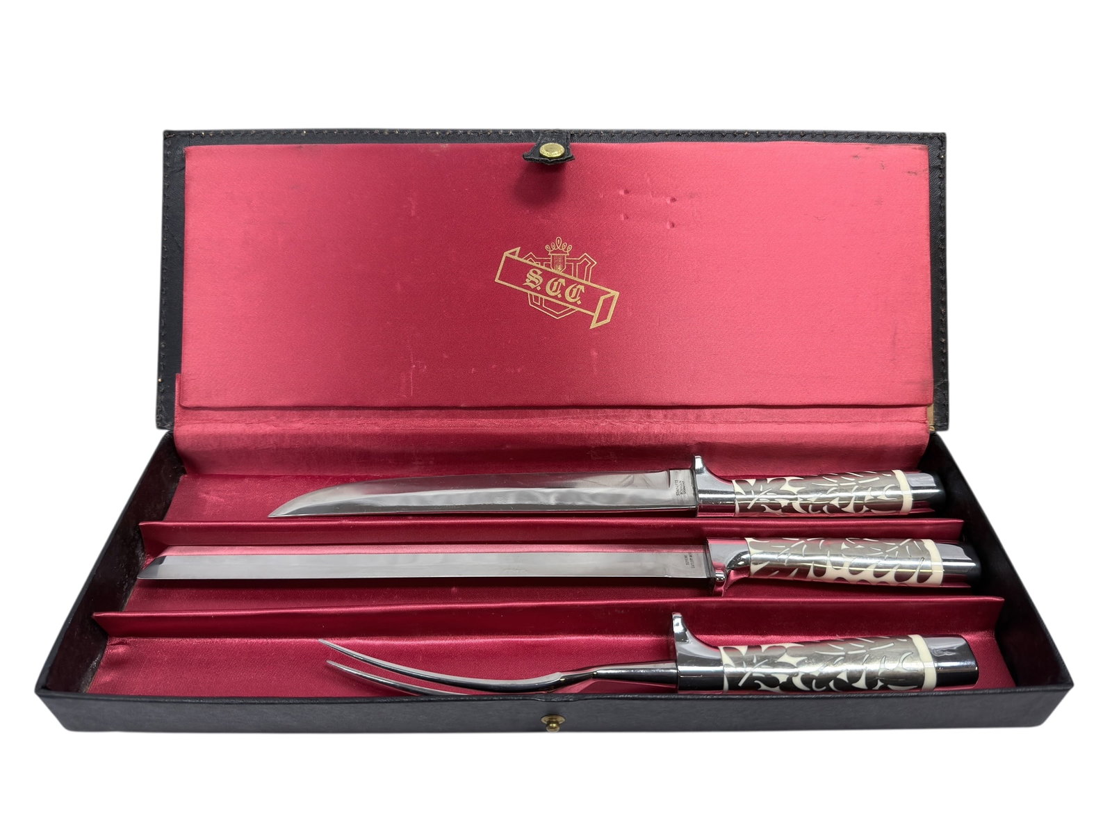 (3Pc) Sheffield Crown Cutlery German Set: (3Pc) Sheffield Crown Cutlery German Set. Handles decorated with silver leaves inlaid over a bone type material. Lid of box marked S.C.C. Each item is marked Stainless Solingen Germany. Both knives me