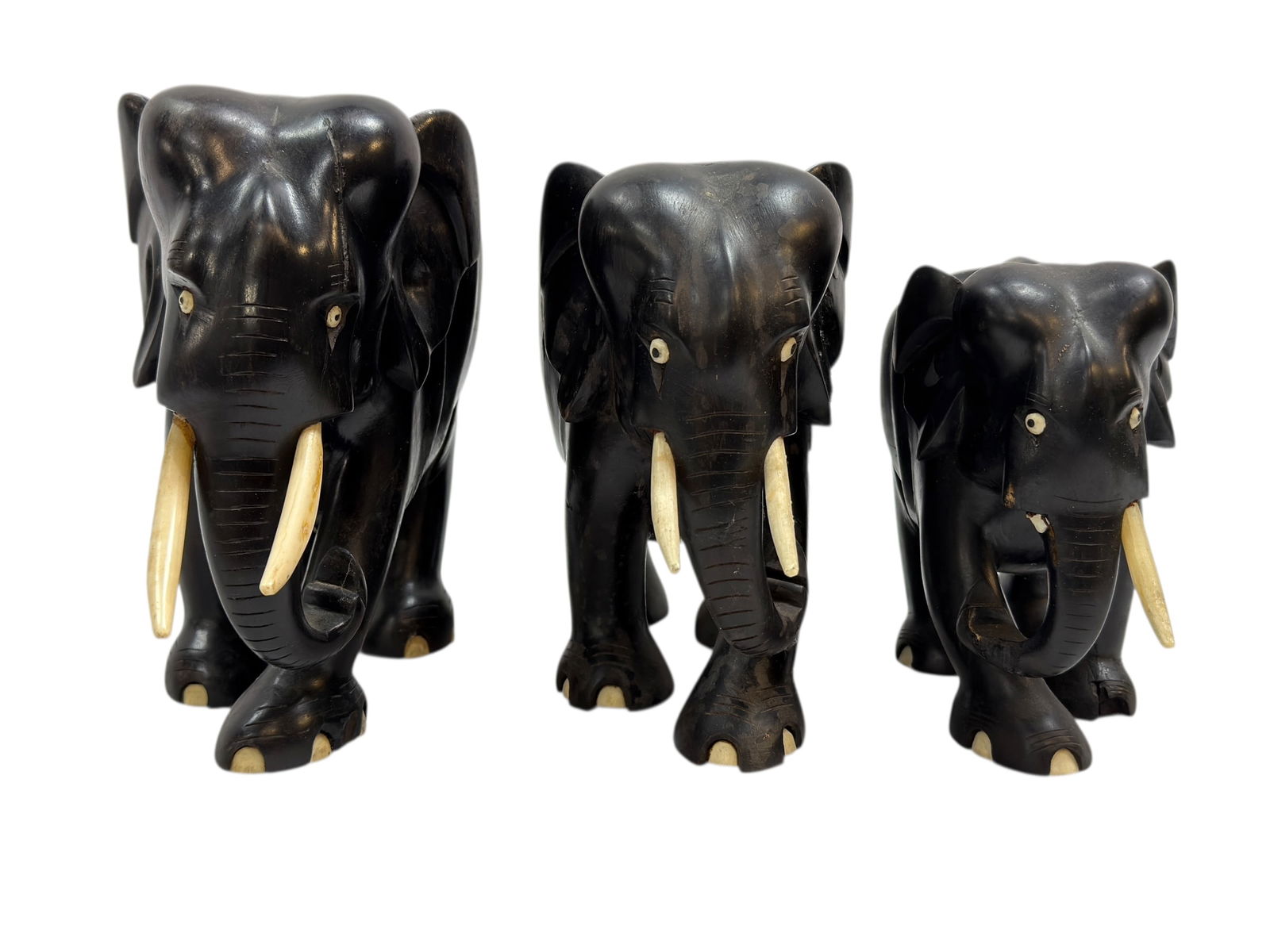 (3) Carved Ebony Wood Elephants w/ Bone Tusk & Toes: (3) Carved Ebony Wood Elephants w/ Bone Tusk & Toes. Measures 8" H x 9.5" W x 4.5" D. Has some damage to the body (see photos). Measures 7.25" H x 8.75" W x 4.25" D & 6" H x 7.25" W x 3.75" D. Bodies