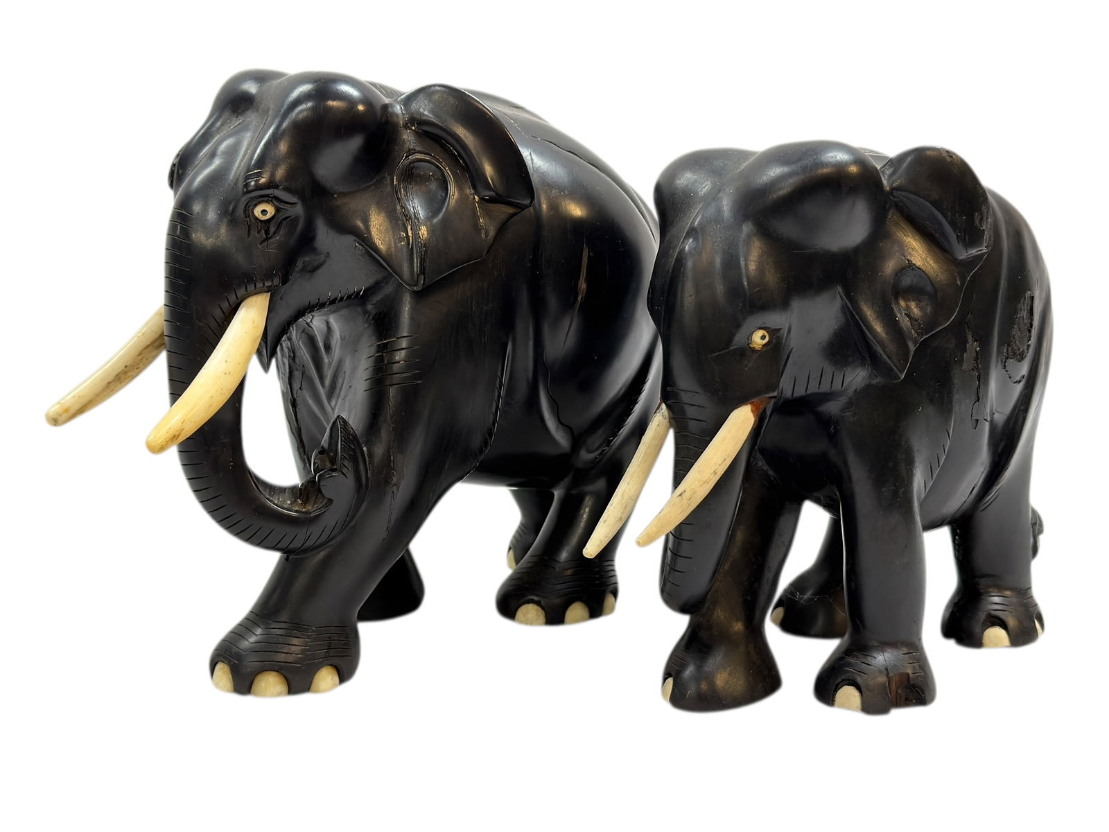 (2) Carved Ebony Wood Elephants w/ Bone Tusk & Toes: (2) Carved Ebony Wood Elephants w/ Bone Tusk & Toes. Measures 9" H x 11" W x 5.25" D. Has some damage to the body (see photos). Measures 10" H x 12" W x 4" D. Missing a toe and has some damage to the